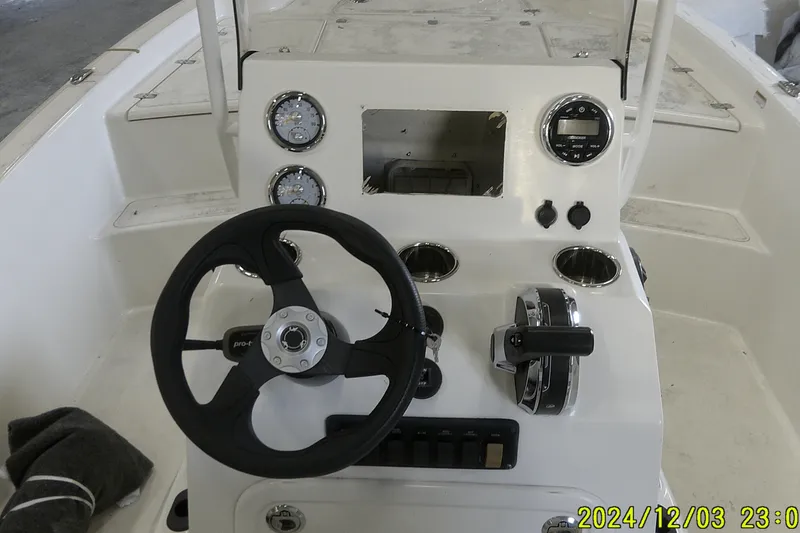 Slide: The Image of 2023 Mako Pro Skiff 19 CC boat console with steering wheel and controls. - 50