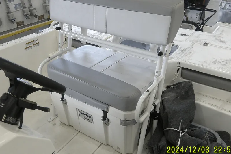 Slide: The Image of 2023 Mako Pro Skiff 19 CC boat interior with steering wheel and cushioned seating. - 51