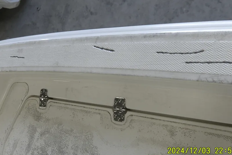 Slide: The Image of 2023 Mako Pro Skiff 19 CC boat interior with visible wear and hinge detail. - 54