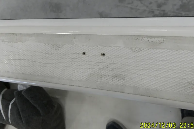 Slide: The Image of 2023 Mako Pro Skiff 19 CC boat detail showing textured surface and small holes. - 55