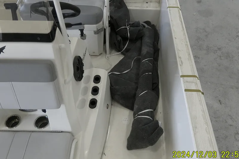 Slide: The Image of 2023 Mako Pro Skiff 19 CC interior with rolled tarp and seating area. - 57