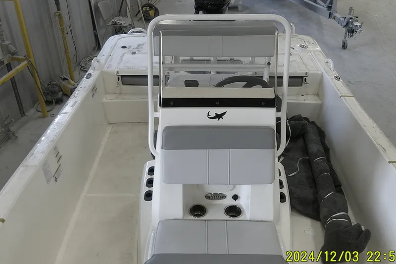 Slide: The Image of 2023 Mako Pro Skiff 19 CC interior view, featuring seating and steering console. - 58