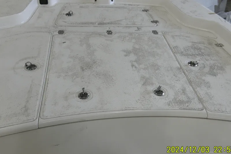 Slide: The Image of 2023 Mako Pro Skiff 19 CC deck with storage hatches and metal fixtures. - 61