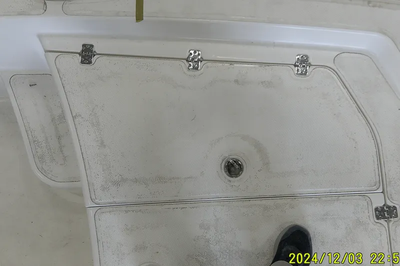 Slide: The Image of 2023 Mako Pro Skiff 19 CC deck with storage hatch and hinges. - 65