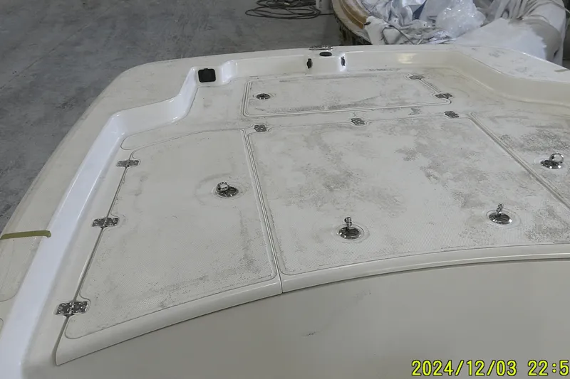 Slide: The Image of 2023 Mako Pro Skiff 19 CC deck with storage compartments, viewed indoors. - 66