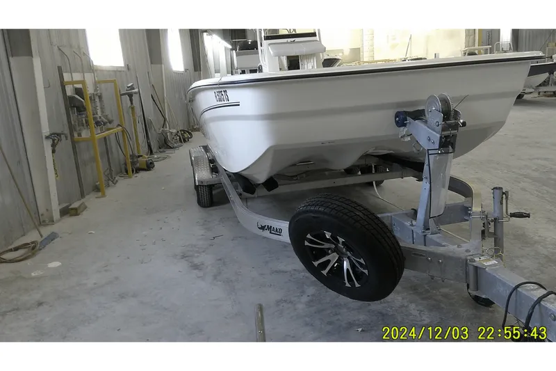 Slide: The Image of 2023 Mako Pro Skiff 19 CC on trailer in a workshop setting. - 69