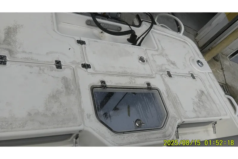 Slide: The Image of 2023 Mako Pro Skiff 19 CC boat deck with storage compartments and timestamp. - 8