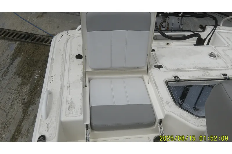 Slide: The Image of 2023 Mako Pro Skiff 19 CC boat interior with seating and storage compartments. - 9