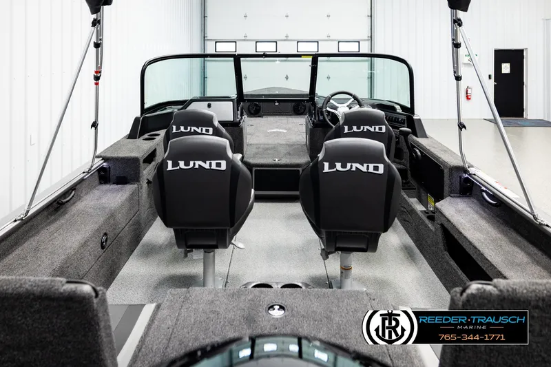 Slide: The Image of 2026 Lund 1875 Impact XS boat interior with branded seats in a showroom. - 12