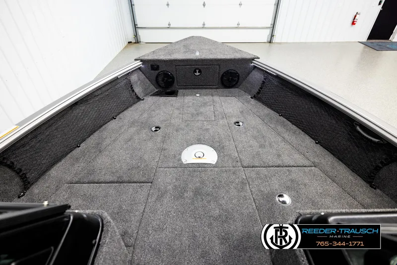 Slide: The Image of 2026 Lund 1875 Impact XS boat interior with carpeted deck and storage compartments. - 14