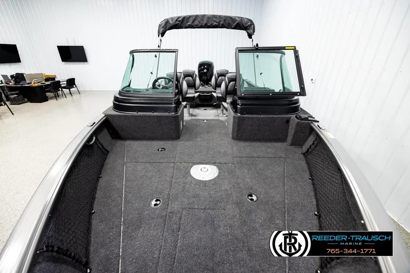 Slide: The Image of 2026 Lund 1875 Impact XS boat interior with spacious deck and seating in showroom. - 15