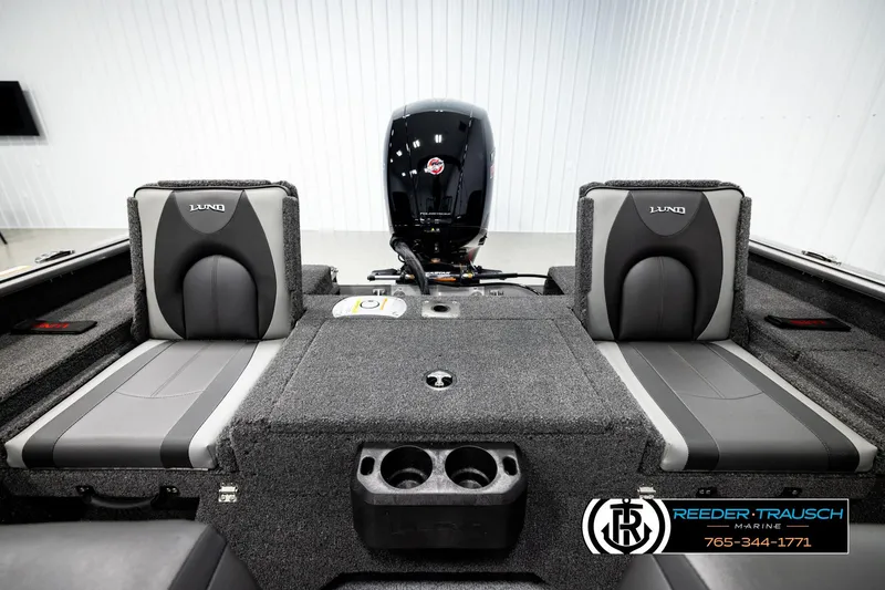 Slide: The Image of 2026 Lund 1875 Impact XS boat interior with gray seating and motor, showcased by Reeder-Trausch Marine. - 17