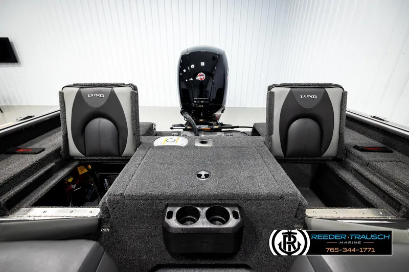 Slide: The Image of 2026 Lund 1875 Impact XS boat interior with motor and seating, featuring Reeder-Trausch Marine branding. - 18