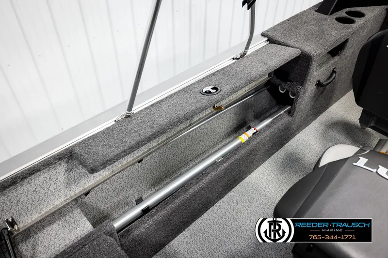 Slide: The Image of 2026 Lund 1875 Impact XS boat interior storage compartment with Reeder-Trausch Marine branding. - 23