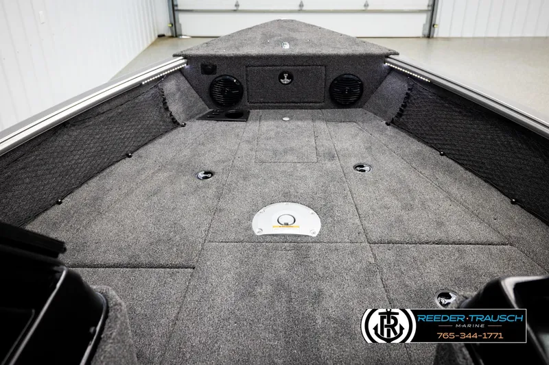 Slide: The Image of 2026 Lund 1875 Impact XS boat interior with carpeted deck and storage compartments. - 24