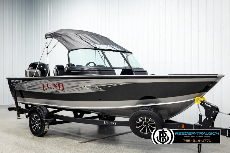 Slide: The Image of 2026 Lund 1875 Impact XS boat with canopy on trailer in showroom. - 3