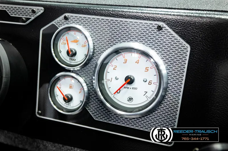 Slide: The Image of Dashboard gauges of 2026 Lund 1875 Impact XS boat, featuring trim, fuel, and RPM indicators. - 36