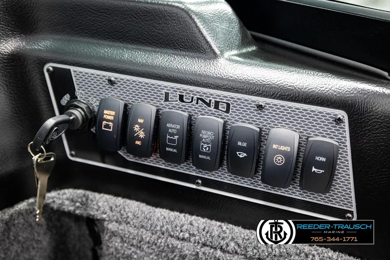 Slide: The Image of Control panel of 2026 Lund 1875 Impact XS boat with various switches and key ignition. - 37