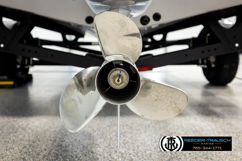 Slide: The Image of 2026 Lund 1875 Impact XS boat propeller close-up in showroom setting. - 50