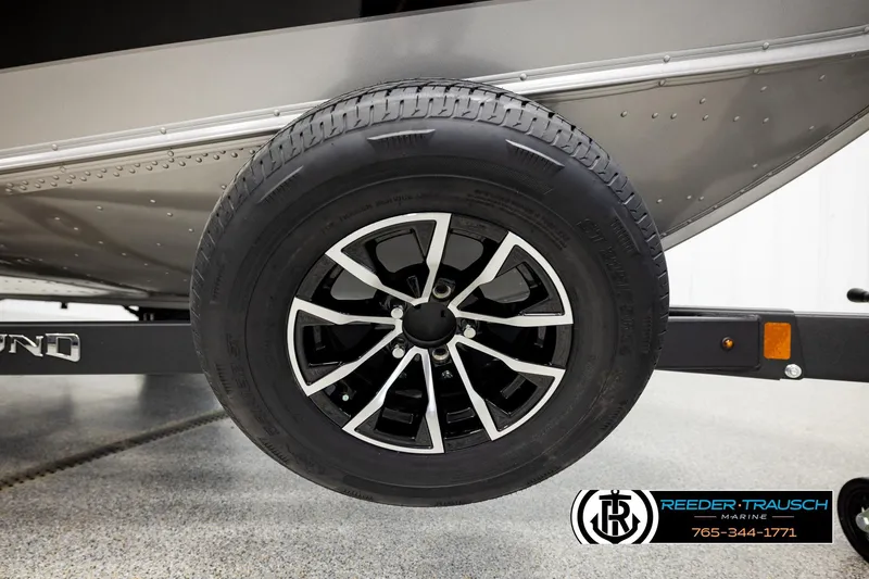 Slide: The Image of 2026 Lund 1875 Impact XS trailer wheel, featuring sleek black and silver design. - 53