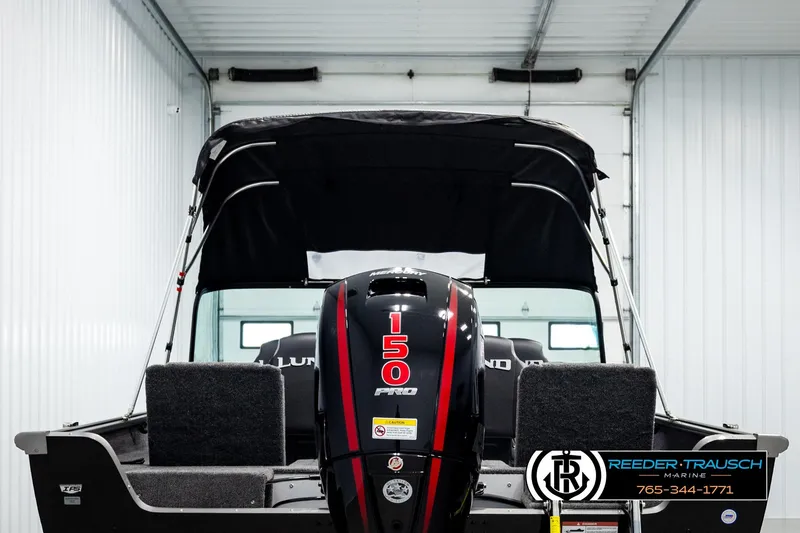 Slide: The Image of 2026 Lund 1875 Impact XS boat with 150 Pro motor in a showroom. - 6
