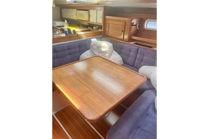 Slide: The Image of Interior of 1995 Catalina 36 MkII sailboat with wooden table and cushioned seating. - 14