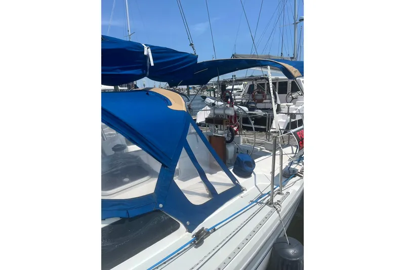 Slide: The Image of 1995 Catalina 36 MkII sailboat with blue canopy docked at marina. - 3
