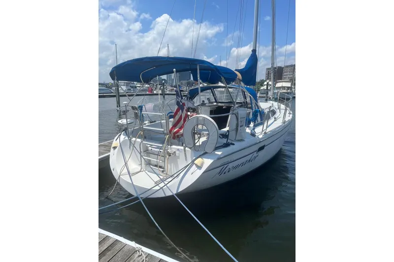 Slide: The Image of 1995 Catalina 36 MkII sailboat docked, featuring blue canopy and American flag. - 5