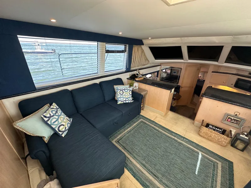Slide: The Image of Interior of 2000 Carver 406 Motor Yacht with blue sofa and nautical decor. - 16