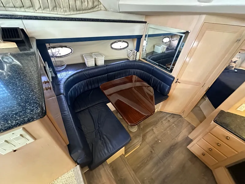 Slide: The Image of 2000 Carver 406 Motor Yacht interior with dining area and leather seating. - 18
