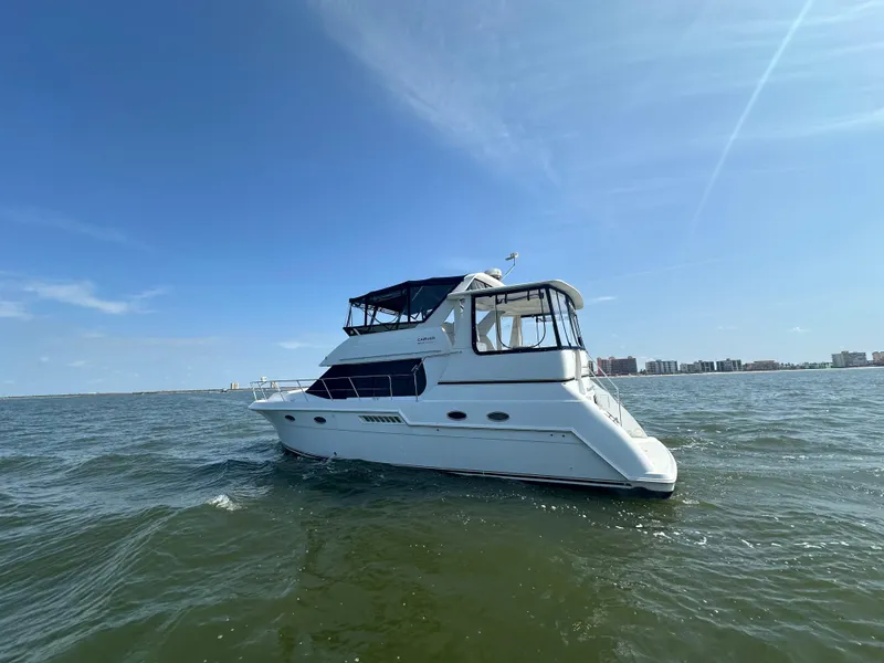 Slide: The Image of 2000 Carver 406 Motor Yacht cruising on open water under a clear blue sky. - 2