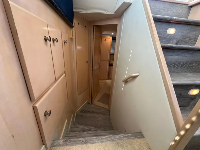 Slide: The Image of Interior stairway of 2000 Carver 406 Motor Yacht with wooden steps and storage cabinets. - 25