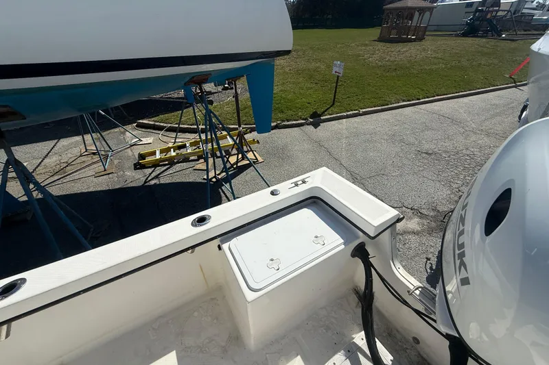 Slide: The Image of 2012 May-Craft 190CC boat with Suzuki engine, parked on a trailer near grassy area. - 11