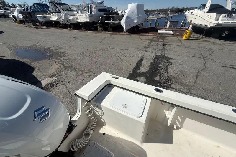 Slide: The Image of 2012 May-Craft 190CC boat docked, with Suzuki engine, near marina with covered boats. - 12