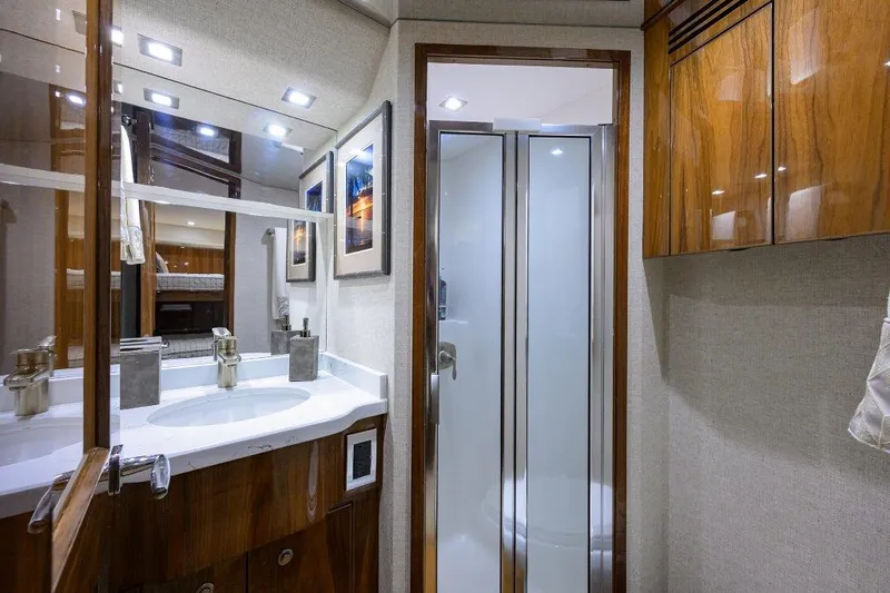 Slide: The Image of Luxurious bathroom in 2020 Viking 72 Convertible yacht with modern fixtures and wood accents. - 21
