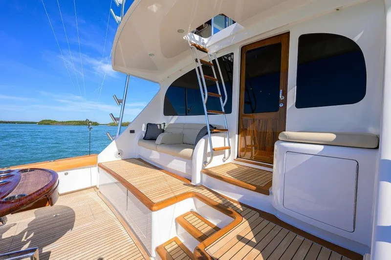 Slide: The Image of Luxurious 2020 Viking 72 Convertible yacht deck with seating, ocean view, and wooden accents. - 26