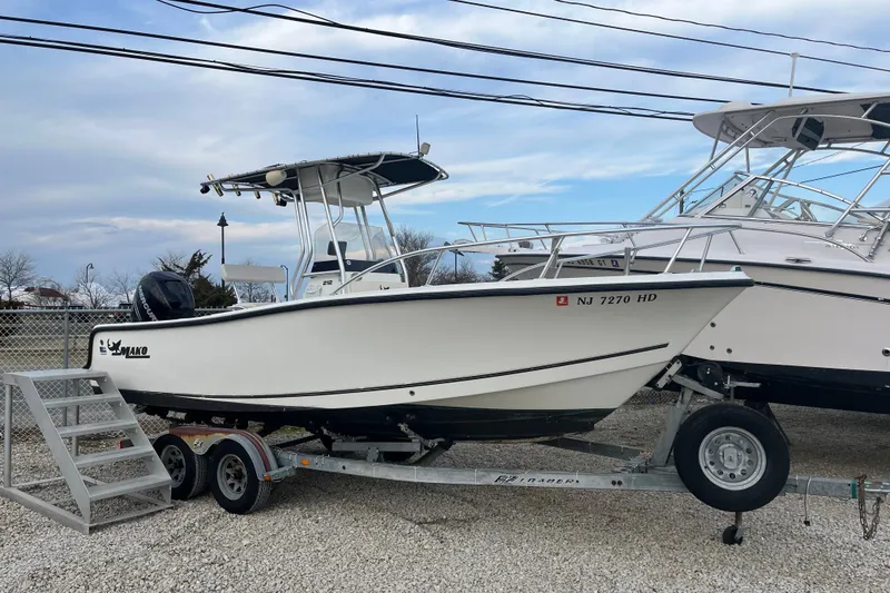 The Image of 2011 Mako 212 Center Console boat on trailer, parked outdoors. - 1