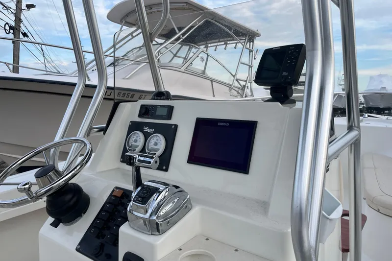 Slide: The Image of 2011 Mako 212 Center Console boat dashboard with steering wheel and navigation equipment. - 3