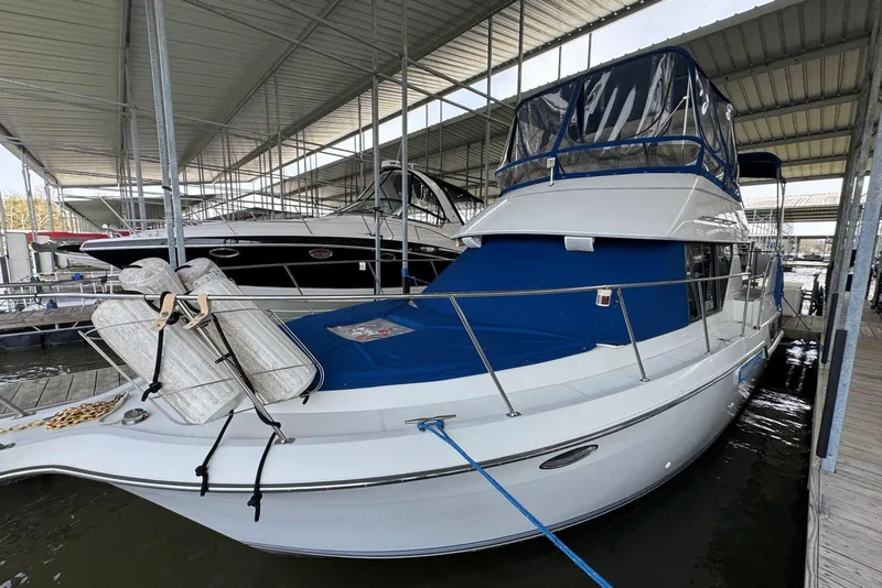 The Image of 1993 Carver 300 Aft Cabin boat docked under covered marina. - 0