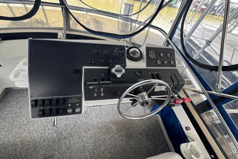 Slide: The Image of 1993 Carver 300 Aft Cabin helm with steering wheel and control panel. - 12