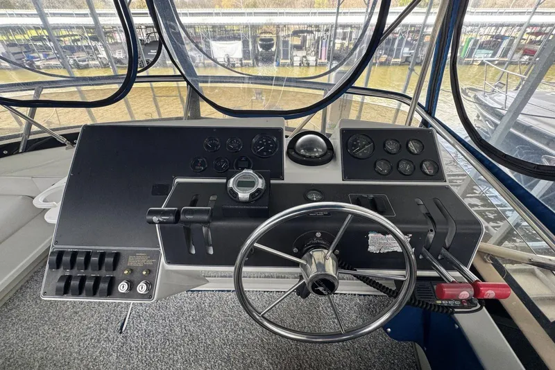 Slide: The Image of 1993 Carver 300 Aft Cabin helm with steering wheel and control panel. - 13