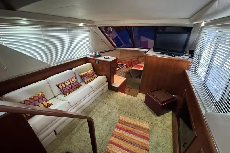 Slide: The Image of 1993 Carver 300 Aft Cabin interior with cozy seating, TV, and nautical decor. - 15