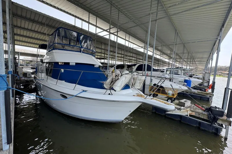 Slide: The Image of 1993 Carver 300 Aft Cabin boat docked in a covered marina. - 2