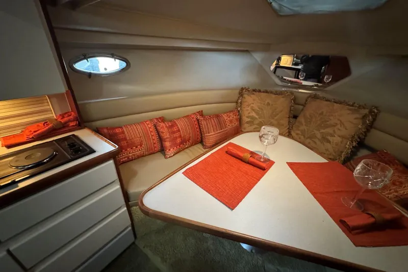 Slide: The Image of Cozy 1993 Carver 300 Aft Cabin interior with dining area and vibrant decor. - 22