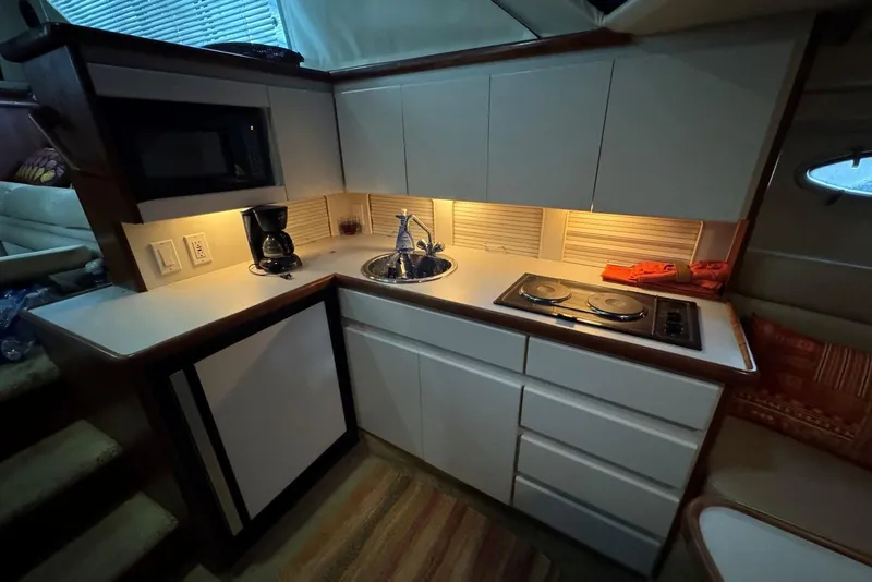 Slide: The Image of Compact kitchen in a 1993 Carver 300 Aft Cabin boat, featuring modern appliances and cabinetry. - 23