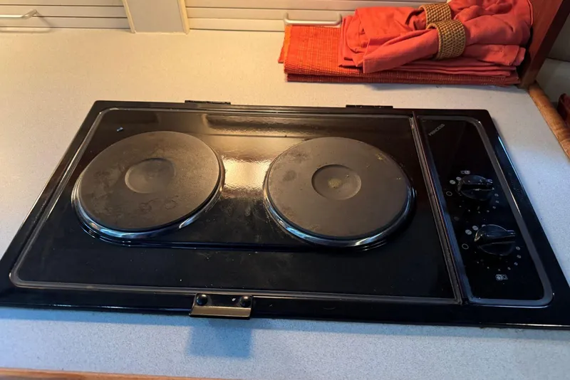 Slide: The Image of Electric stove in 1993 Carver 300 Aft Cabin boat kitchen, with two burners and control knobs. - 24