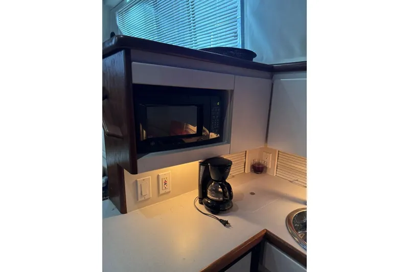Slide: The Image of 1993 Carver 300 Aft Cabin kitchen with microwave, coffee maker, and countertop. - 27