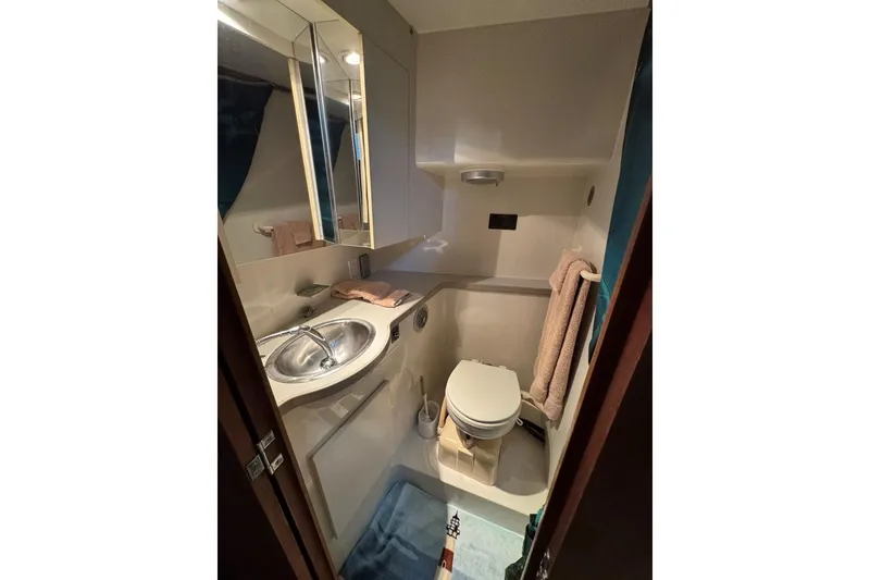Slide: The Image of Compact bathroom in 1993 Carver 300 Aft Cabin yacht with sink, toilet, and mirror. - 28