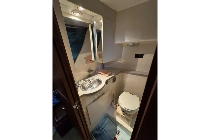 Slide: The Image of 1993 Carver 300 Aft Cabin bathroom with sink, mirror, and toilet. - 29