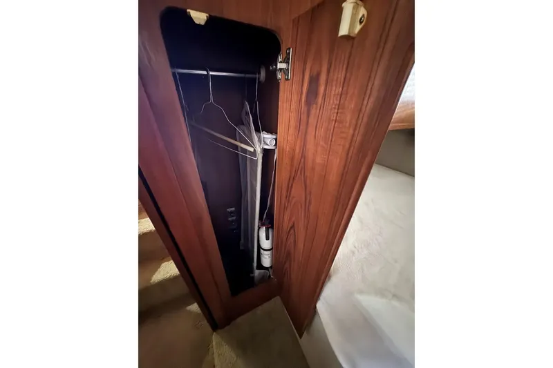 Slide: The Image of 1993 Carver 300 Aft Cabin closet with hangers and wooden finish. - 37